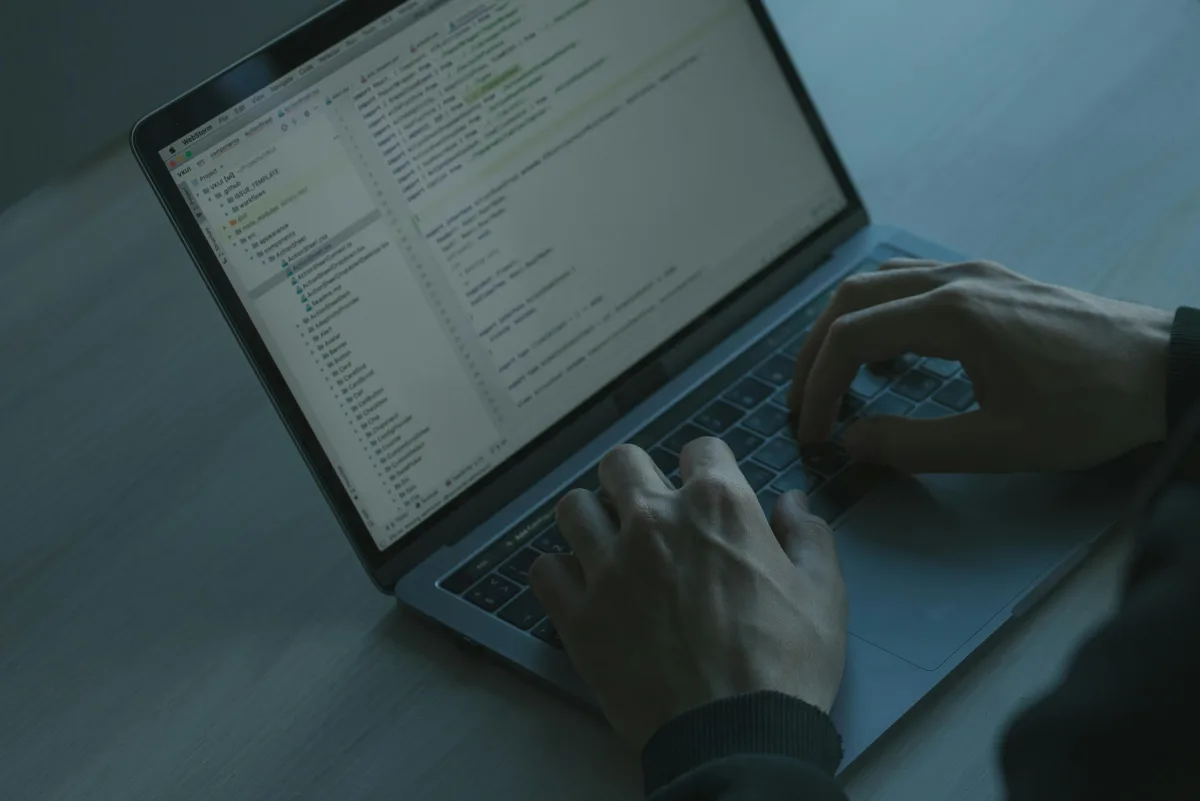 Person tippt auf Laptop mit Entwicklungsumgebung und baut Cybersicherheit-Fähigkeiten auf