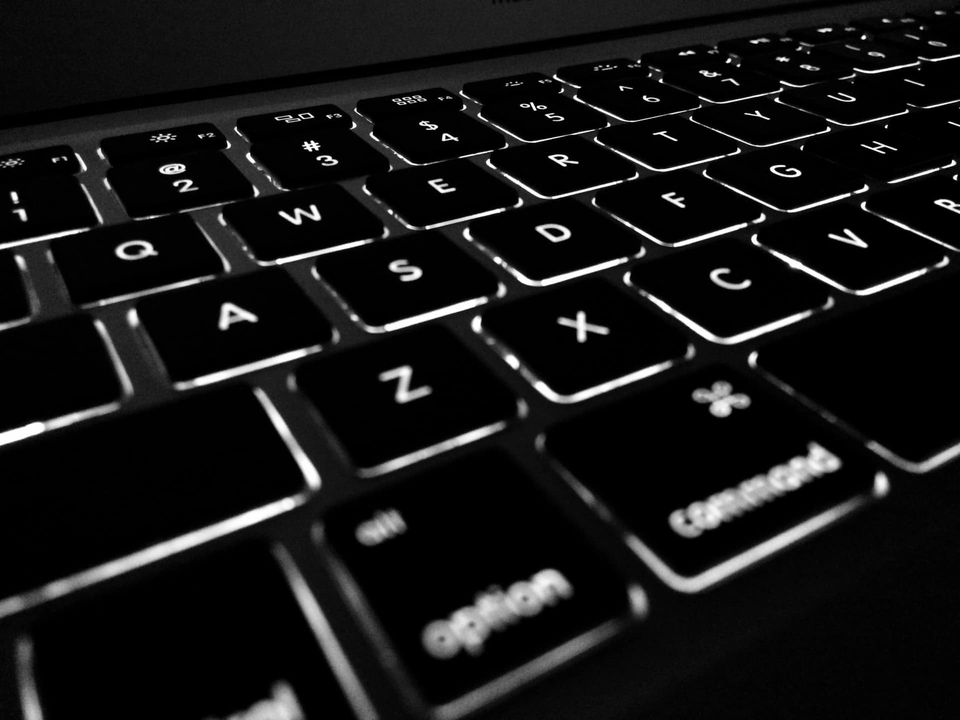 Fachkraft überprüft Compliance-Frameworks auf einem Laptop-Bildschirm mit Cybersicherheits-Richtliniendokumenten im Hintergrund